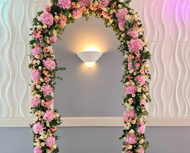 Arche fleurie de roses et d’hortensias roses pour une cérémonie