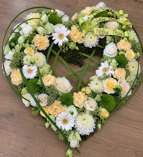 Cœur ouvert de roses crème, marguerites et feuillages