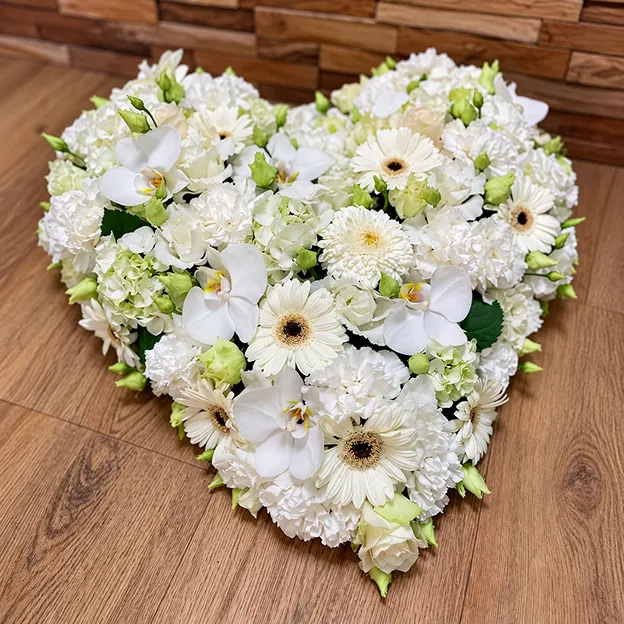 Cœur funéraire de fleurs blanches, orchidées et gerberas