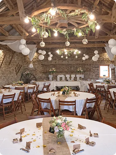 Salle de réception de mariage décorée de suspensions florales et de bougies